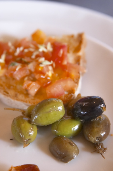 Tärnade solmogna tomater på en rostad skiva lantbröd och oliver