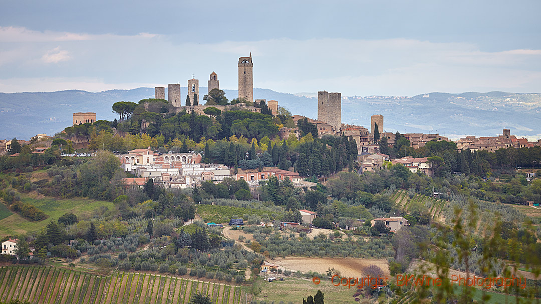 En by i Toscana på en kulle med sina typiska torn och vingårdar