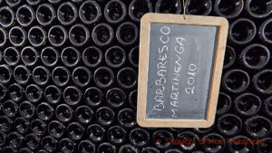 Flaskor med barbaresco vilar i vinkällaren i Piemonte