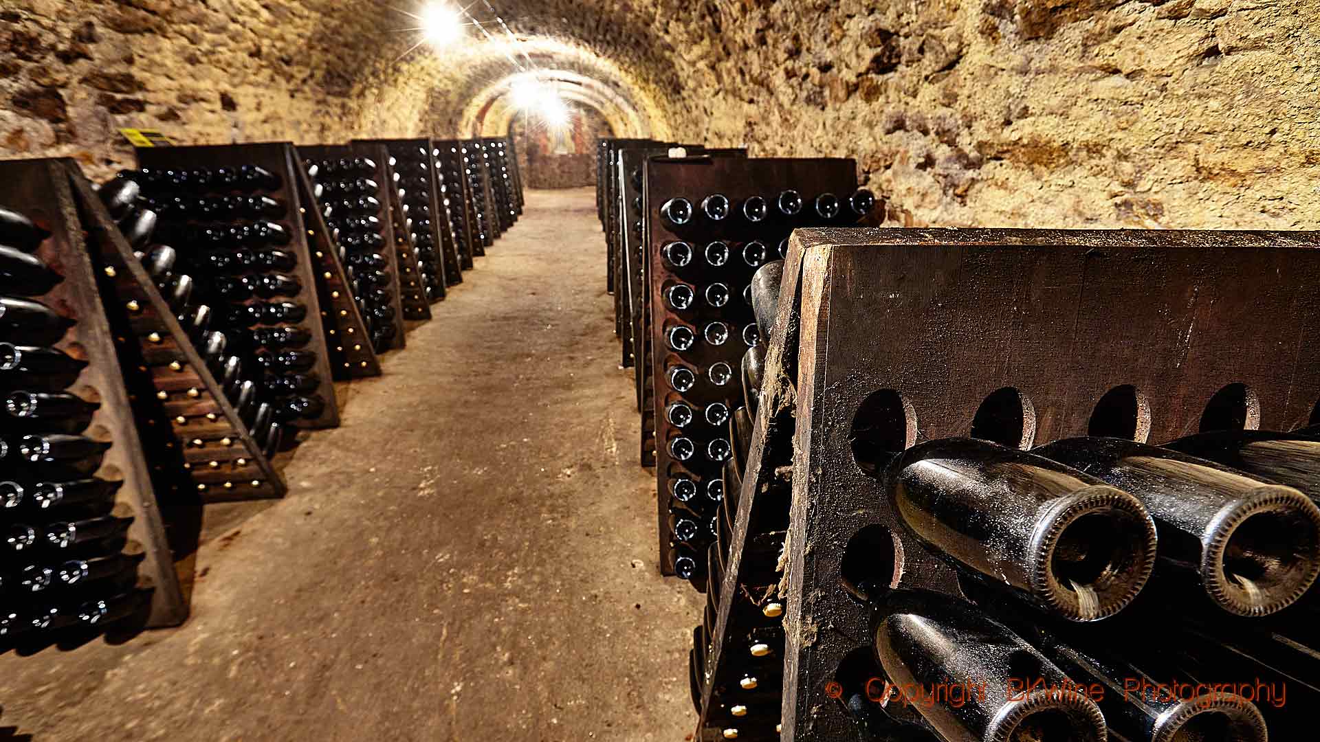 Flaskor i pupitres i en utgrävd källargång i Champagne