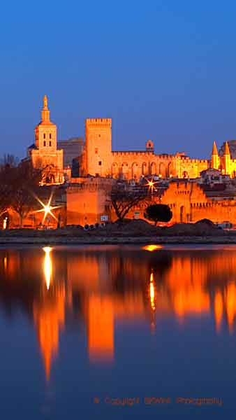 Påvepalatset i Avignon i skymningen över floden