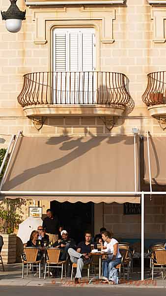 En caféterrass med ett vackert hus i solen i Sitges, Katalonien