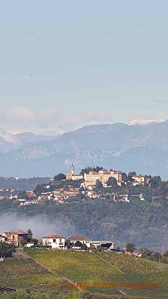 Vingårdar och en by med ett slott och berg i Piemonte