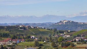 Vingårdar och en by med ett slott och berg i Piemonte