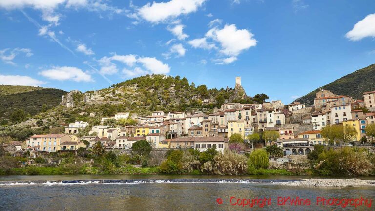En by som klättrar upp på berget längs en flod i Languedoc